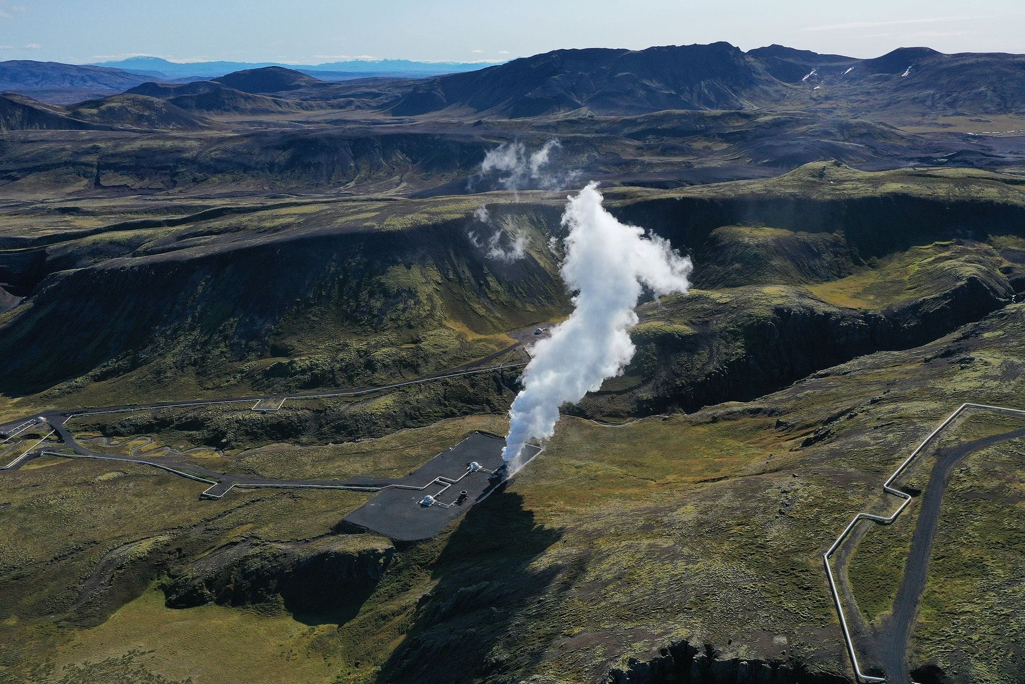 Gufustrókur upp úr jörðinni, loftmynd af íslenskri náttúru mosa og fjalllendi