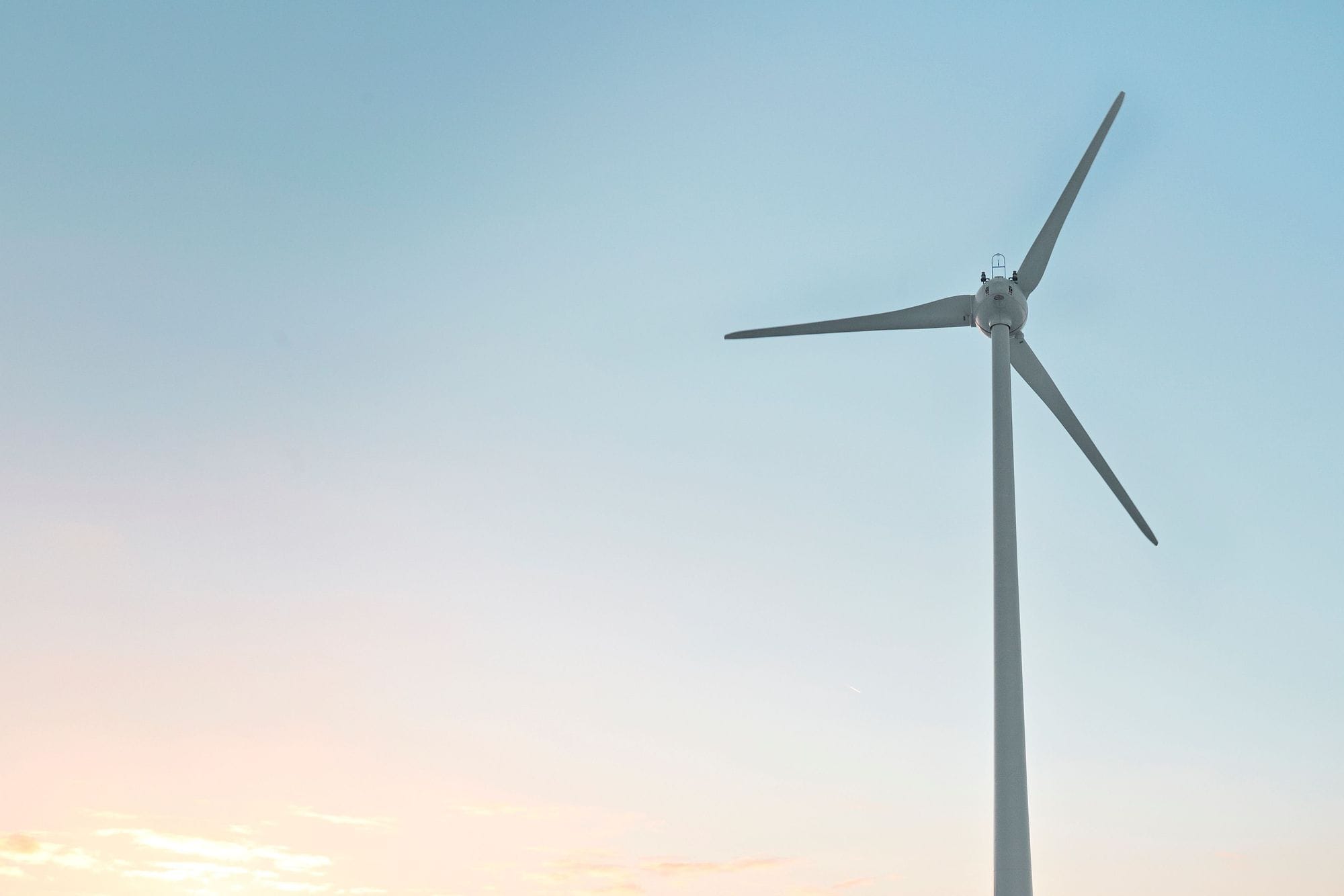 a wind turbine under blue sky